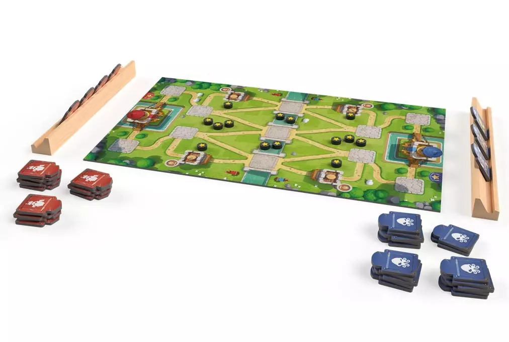 Terrain de jeu avec plateau coloré, pions et cartes empilées rouges et bleues, sets de blocs en bois sur les côtés.